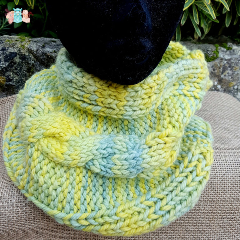 Cache cou, snood sur manequin en mérinos alpaga en bleu, vert et jaune, avec une torsade centrale, fabriqué en france, merino, alpaca