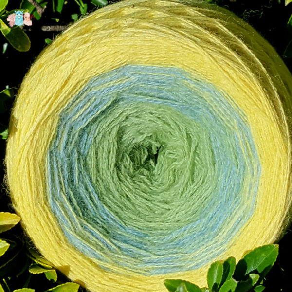 Gros plan pelote de laine en cake de dégradé de coloris gradient jaune, bleu et vert, Fabriquée en france