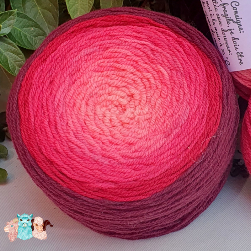 Détails d'une pelote cake laine mérinos en dégradé rouge -violet aux couleurs naturelles grand teint. Fabrication française