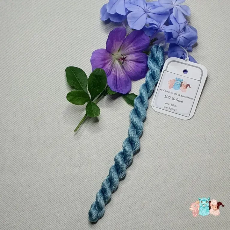 Echeveau de fil de soie bleu avec des fleurs sur fond gris, fabriqué en france