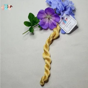 Echeveau de fil de soie jaune clair avec des fleurs sur fond gris, fabriqué en france