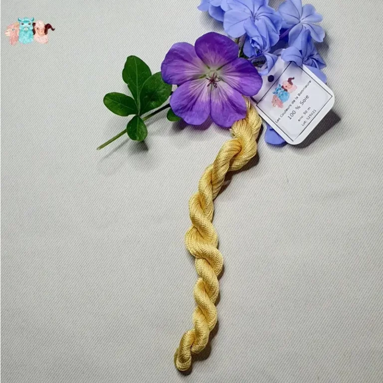 Echeveau de fil de soie jaune clair avec des fleurs sur fond gris, fabriqué en france