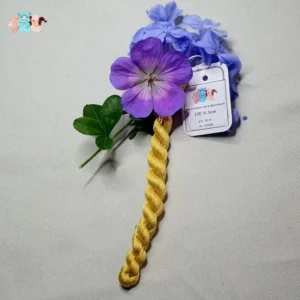 Echeveau de fil de soie jaune foncé avec des fleurs sur fond gris, fabriqué en france