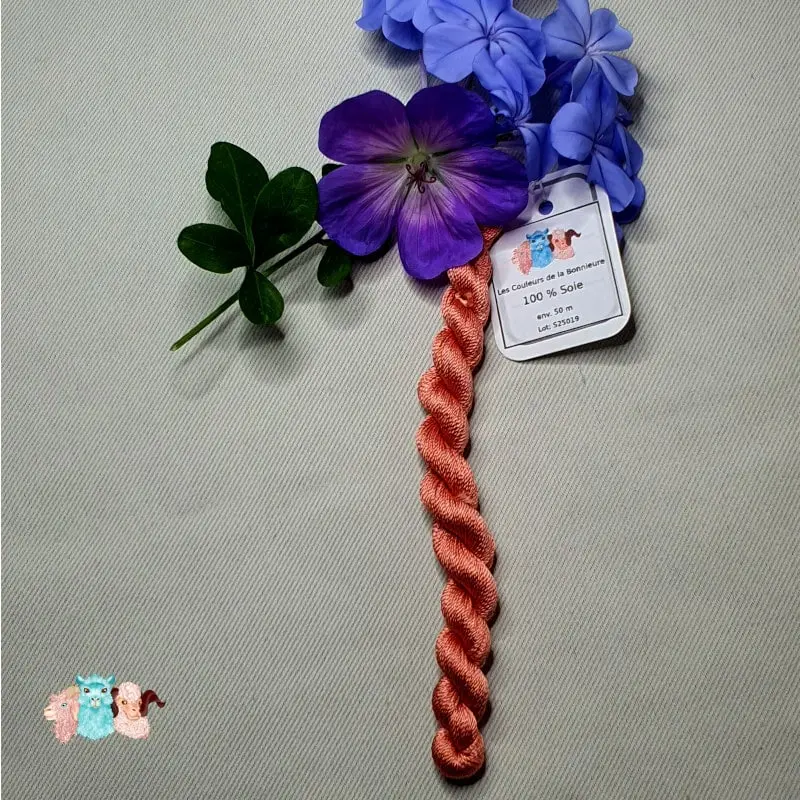 Echeveau de fil de soie rose chair avec des fleurs sur fond gris, fabriqué en france