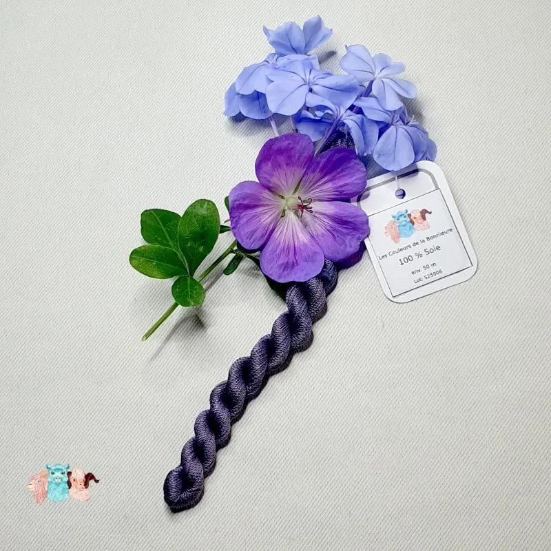 Echeveau de fil de soie violet foncé avec des fleurs sur fond gris, fabriqué en france