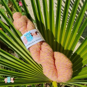 Echeveau de laine chinée violet et jaune, sur fond de feuilles vert, fabrication française