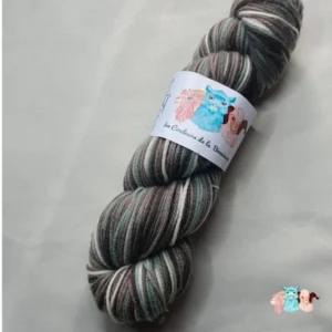 Echeveau de laine mérinos multicolore gris bleuté avec des nuances sur un fond gris