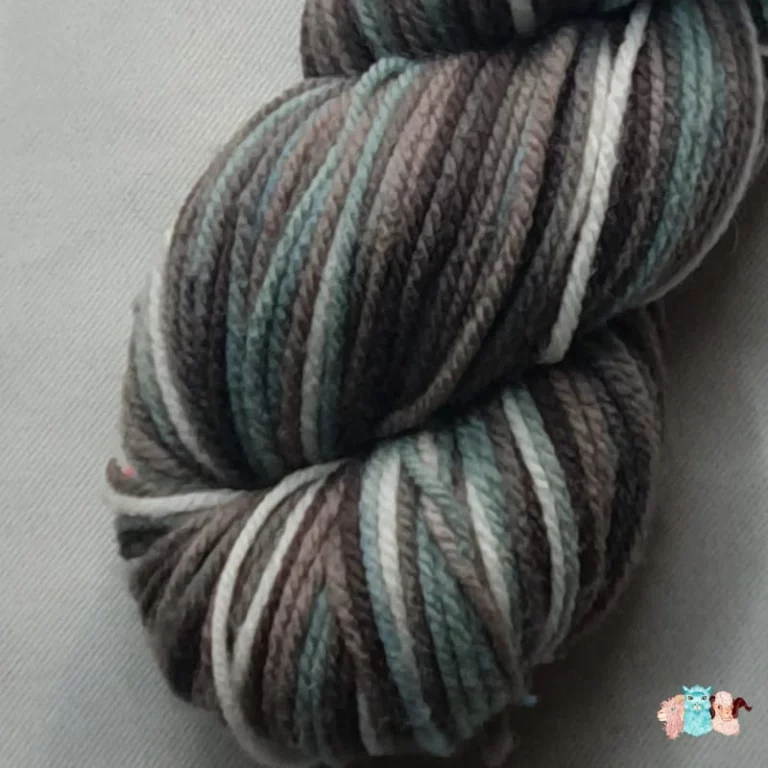 Gros plan écheveau de laine mérinos multicolore gris bleuté avec des nuances sur un fond gris