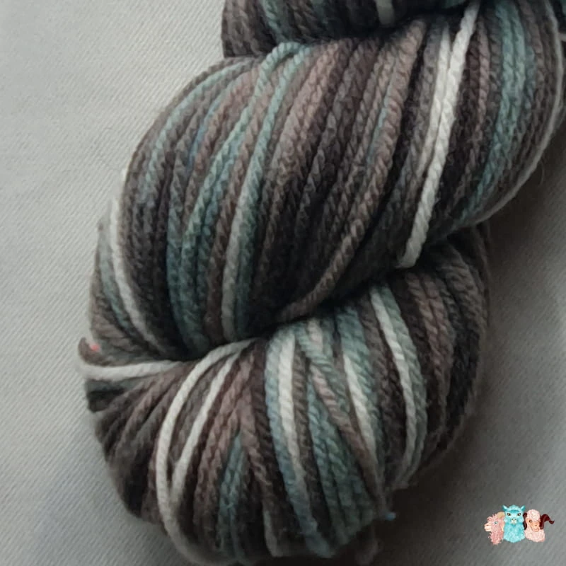 Gros plan écheveau de laine mérinos multicolore gris bleuté avec des nuances sur un fond gris