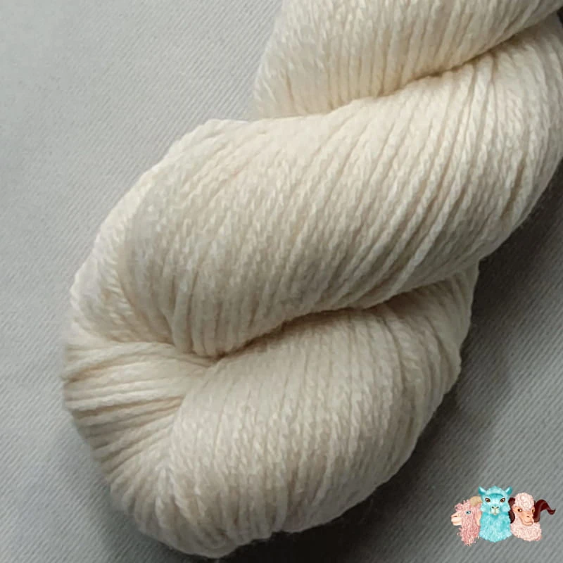 Gros plan écheveau de laine mérinos naturelle écru sur un fond gris.