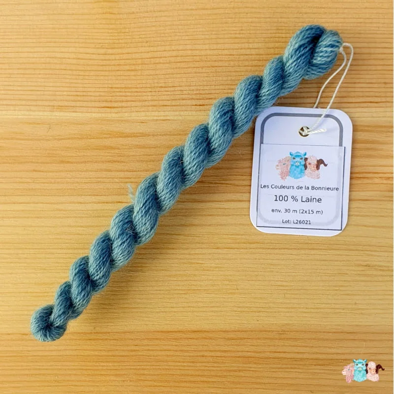 laine-broderie_bleu_clair Echeveau de fil de laine bleu clair sur fond bois, fabriqué en france