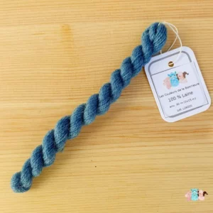 Echeveau de fil de laine bleu moyen sur fond bois, fabriqué en france