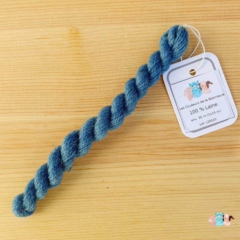 Echeveau de fil de laine bleu moyen sur fond bois, fabriqué en france