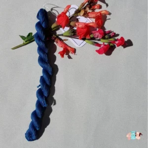 Echeveau de fil de soie bleu indigo foncé avec des fleurs sur fond gris, fabriqué en france