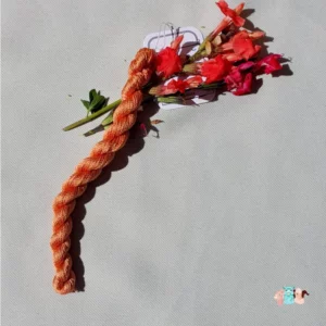 Echeveau de fil de soie orange clair avec des fleurs sur fond gris, fabriqué en france