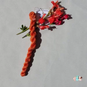 Echeveau de fil de soie orange moyen avec des fleurs sur fond gris, fabriqué en france