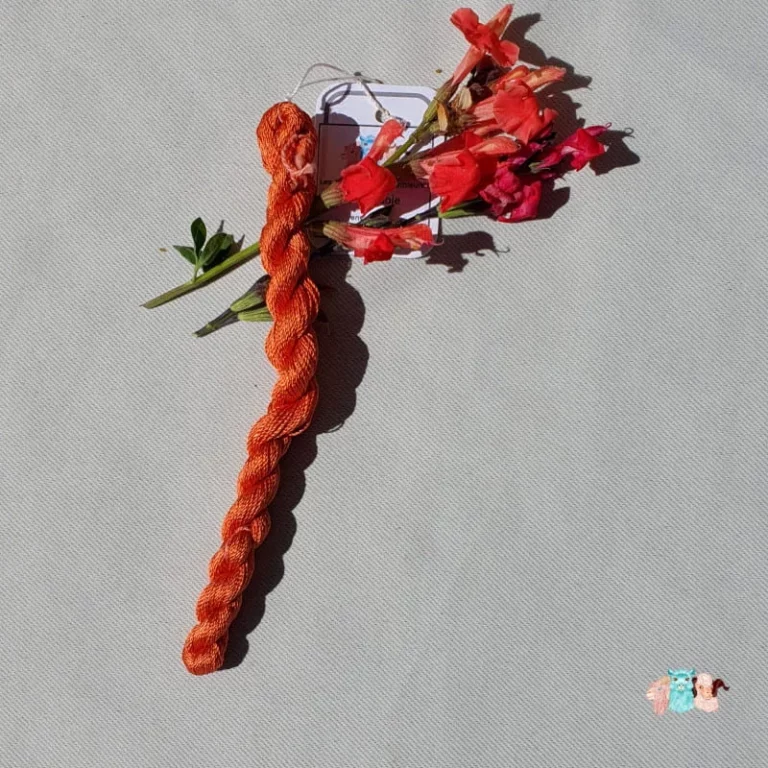 Echeveau de fil de soie orange moyen avec des fleurs sur fond gris, fabriqué en france