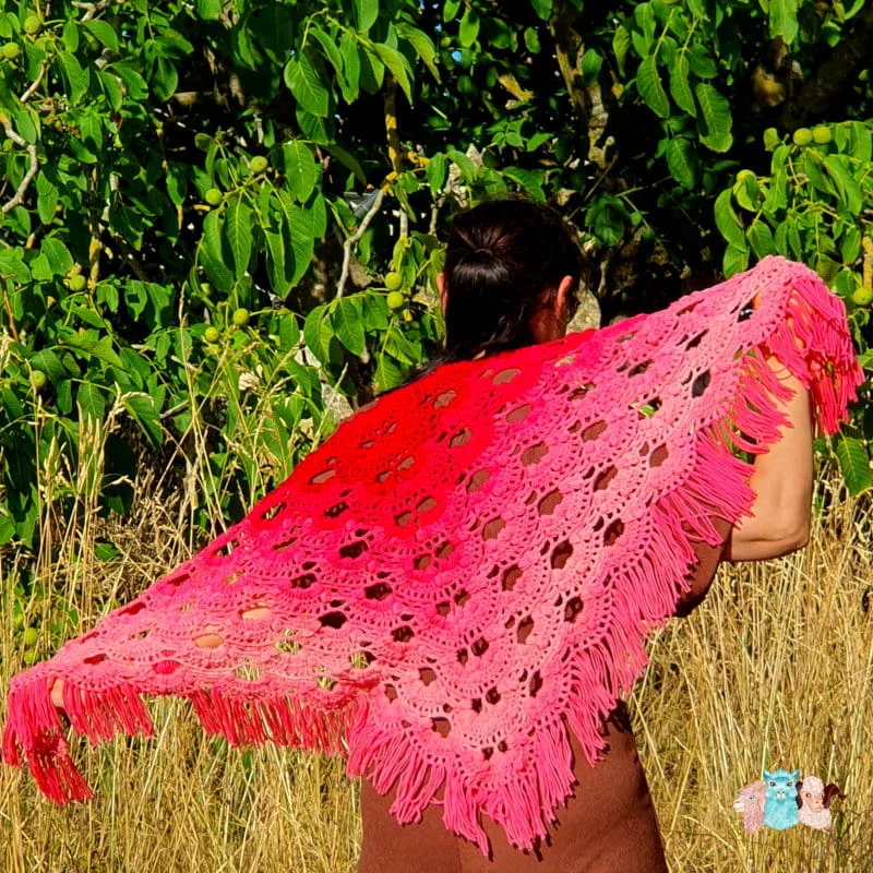 Châle avec des franges en laine mérinos d'Arles de coloris dégradé rouge porté.